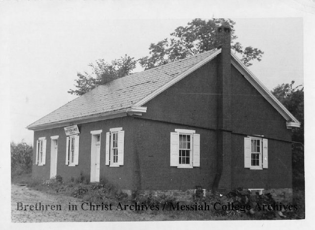 A black-and-white photo of an old brick building.